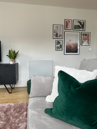 Living room with green pillow and wall art.