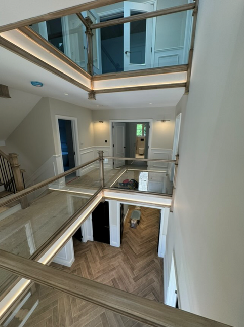 Modern interior with glass railings and wooden flooring.