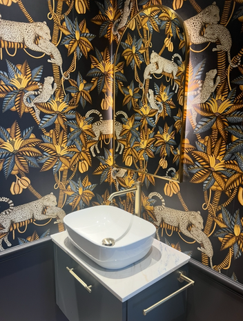 Vibrant wallpaper with leopards and tropical leaves.