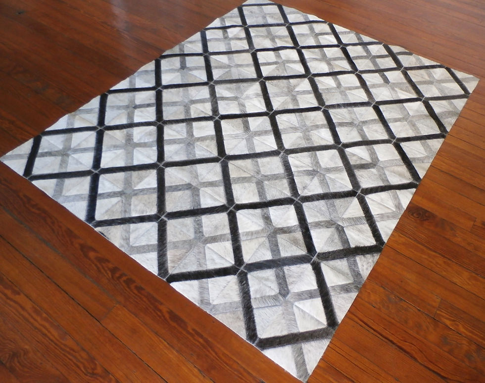 Thumbnail: Hurlingham hide rug in 6 x 6 inch panels of charcoal, off white, and light grey on a modern living room floor, handmade luxur