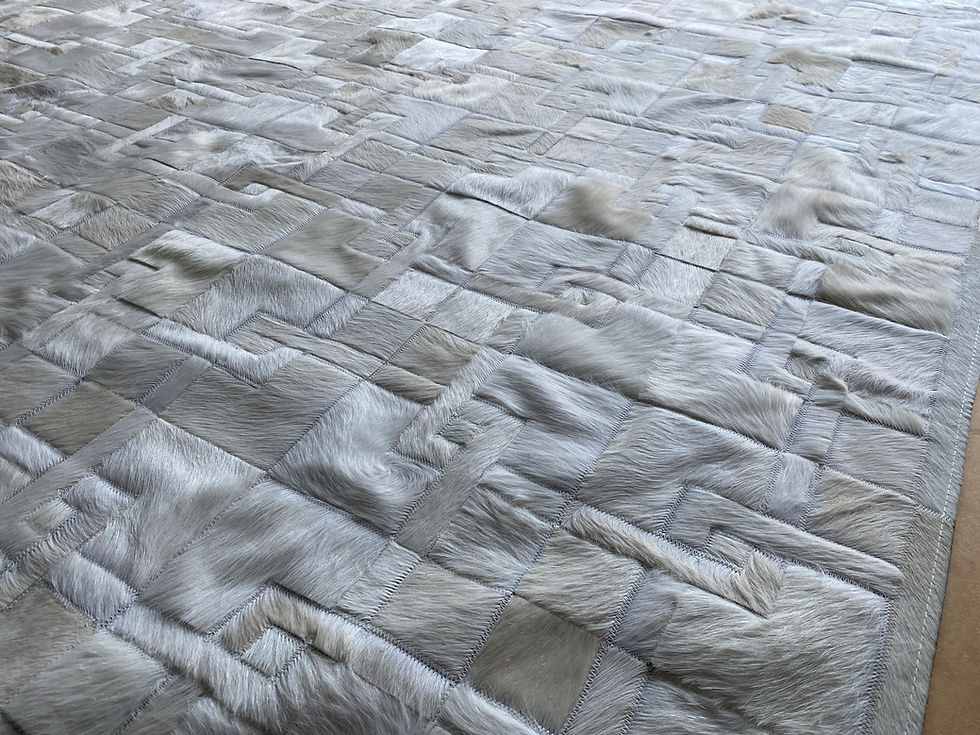 Thumbnail: Pergamino cowhide patchwork rug with stepped‑border, maze‑like pattern on the floor