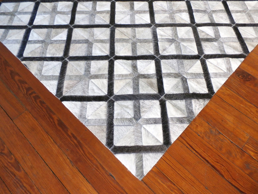 Thumbnail: Hurlingham hide rug in 6 x 6 inch panels of charcoal, off white, and light grey on a modern living room floor, handmade luxur