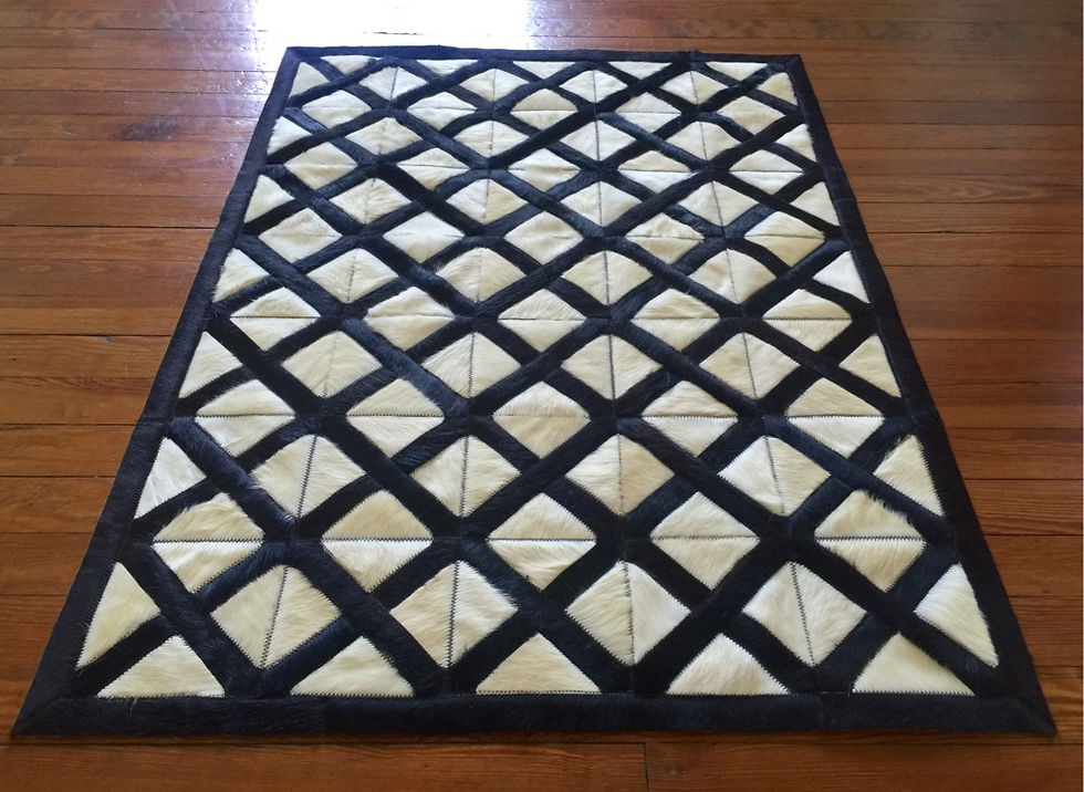 Thumbnail: Hurlingham hide rug in 6 x 6 inch panels of charcoal, off white, and light grey on a modern living room floor, handmade luxur