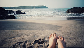 two bare feet in the sand at a private community beach cove by Doranja house