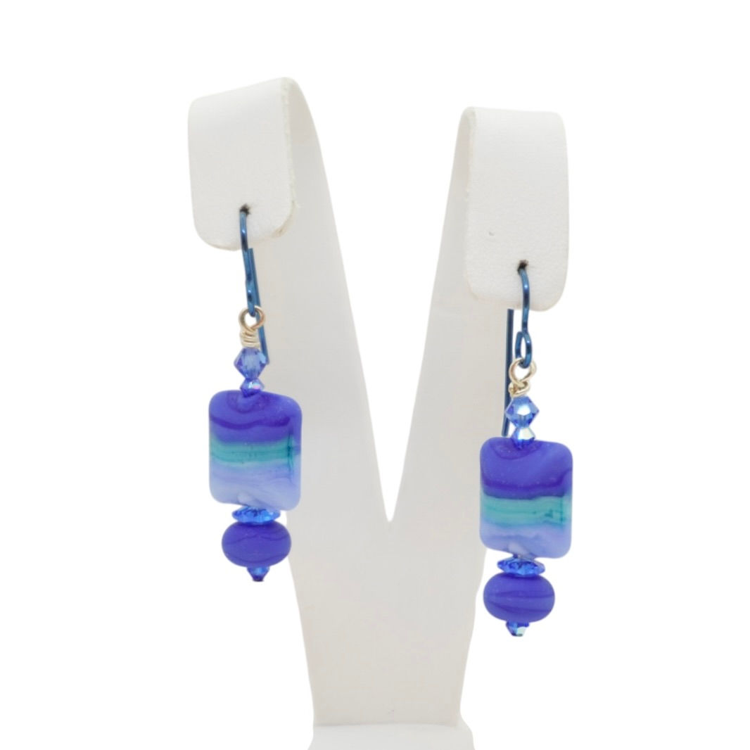 Blue lampwork bead earrings on earring display