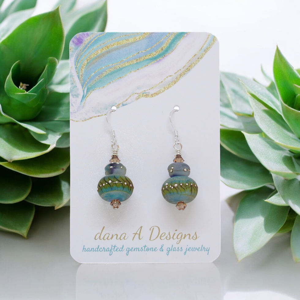 Thumbnail: Lampwork earrings on earring display near succulent plants