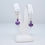 Thumbnail: purple lampwork bead earrings on a white earring display