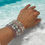 Thumbnail: Gemstone bracelets on a woman's wrist near the water