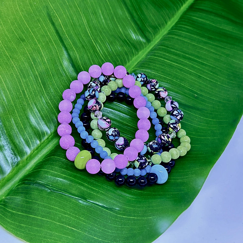 colorful gemstone bracelets on a green tropical leaf
