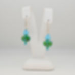 Green and turquoise lampwork earrings on earring display