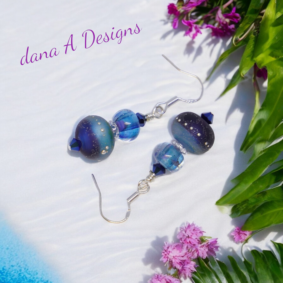 Thumbnail: Blue lampwork bead earrings on beach sand