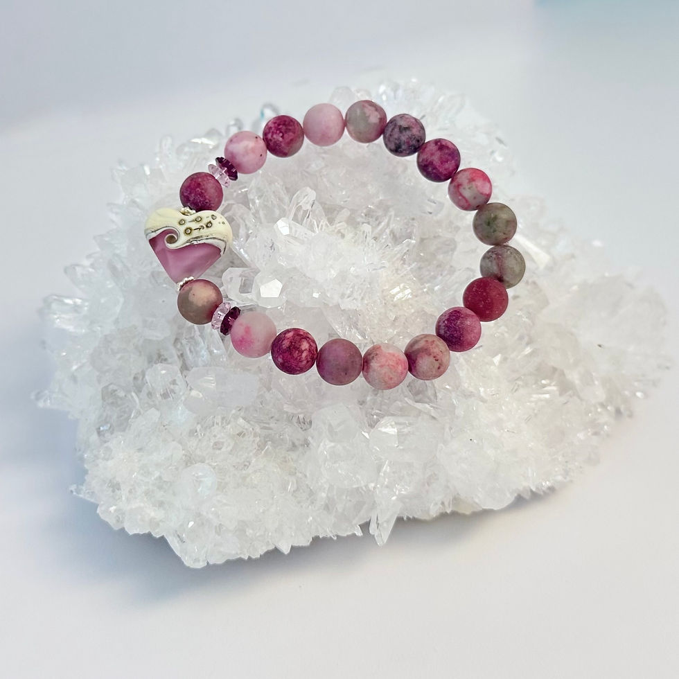 gemstone and lampwork bead bracelet laying on a large crystal