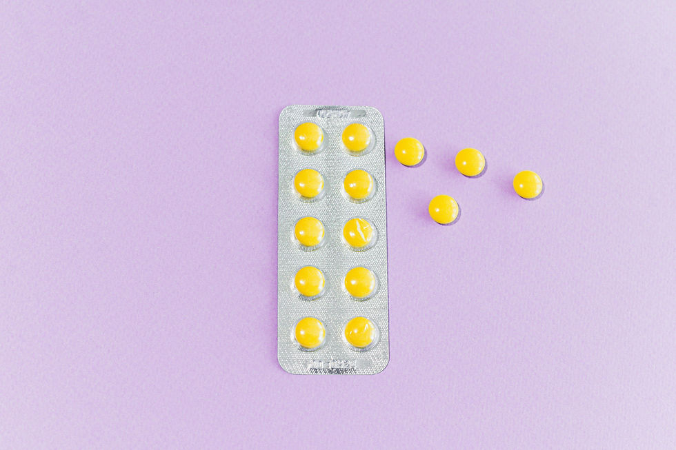 Yellow pills in blister pack and loose on purple background. Pills are round and glossy, creating a contrast with the soft backdrop.