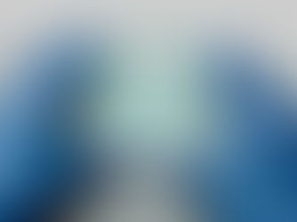 Gloved hands holding a Petri dish with small black specks on a light blue medium, set against a neutral surface.