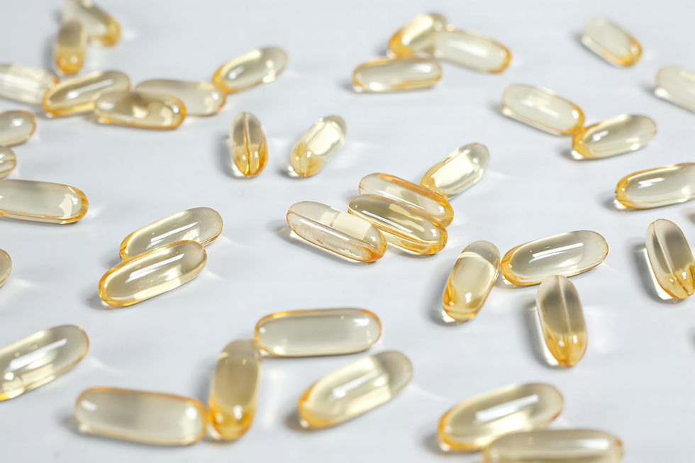 Yellow-tinted capsules scattered on a white surface, reflecting light. The mood is neutral and focused on the clear, glossy capsules.