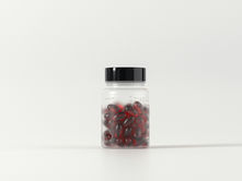 Clear jar with black lid containing red capsules, labeled "Omega+ Fish Oil". Set against a plain white background.