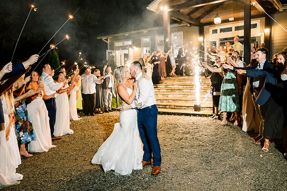 bride and groom sharing a kiss as they celebrate with a sparkler exit after their big day