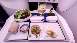 delicious salad and scallop appetizer tray with fresh warm bread Business class seat Air France A350 with full recline lay flat seat and extra legroom. Luxury flight. Luxury Travel Blog.