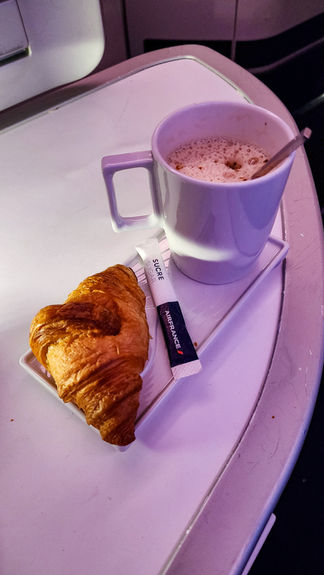 Croissant and latte breakfast Business class seat Air France A350 with full recline lay flat seat and extra legroom. Luxury flight. Luxury Travel Blog.