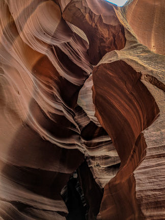Narrow passage in antelope canyon with smooth, wave-like sandstone walls in shades of red and orange, illuminated softly from above on Elegant Escape, the best luxury travel blog.