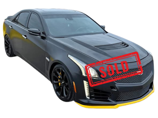 Black 2017 Cadillac CTS-V with matte black wrap, yellow front splitter, carbon wing, and black wheels parked in Dayton, Ohio at Dayton Premier Auto.