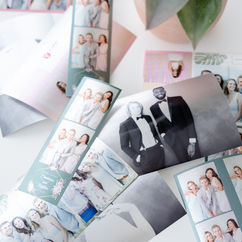 Scattered photo booth strips featuring smiling couples and friends from events.