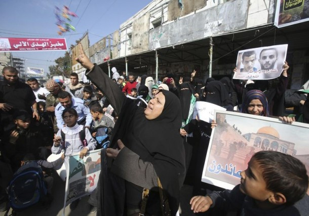 A Palestinian woman scatters sweets as she celebrates with others an attack on a Jerusalem synagogue, in Rafah in the southern Gaza Strip November 18, 2014. Two Palestinians armed with a meat cleaver and a gun killed four people in a Jerusalem synagogue on Tuesday before being shot dead by police, the deadliest such incident in six years in the holy city amid a surge in religious conflict. REUTERS/Ibraheem Abu Mustafa (GAZA - Tags: POLITICS CIVIL UNREST TPX IMAGES OF THE DAY)