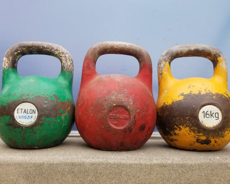 three kettlebells in a line - an image that is supposed to embody the benefits of kettlebell training