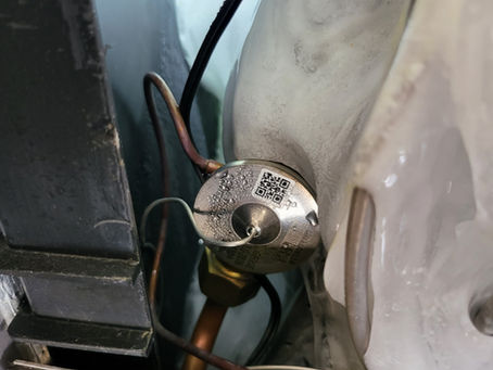 Evaporator coil with ice buildup caused by a stuck TXV valve restricting refrigerant flow.