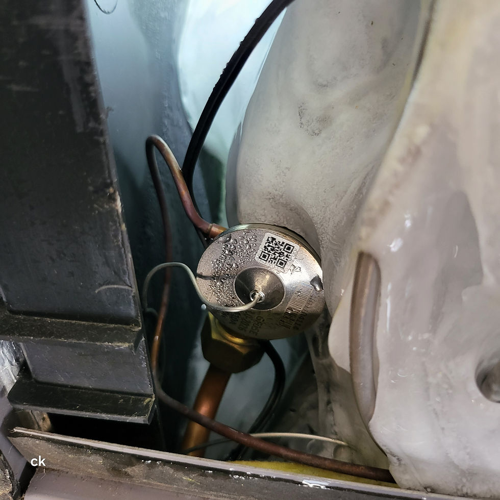 Evaporator coil with ice buildup caused by a stuck TXV valve restricting refrigerant flow.