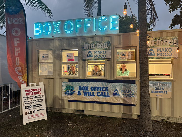 The Box Office at the Key West Amphitheater with its neon sign up top and three friendly faces in the windows..
