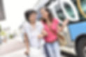 Caregiver assisting their client walk to get on a bus