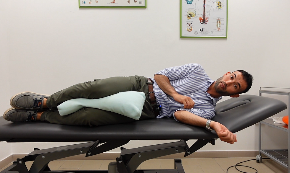 Il Fisioterapista Davide Diamantini mostra la posizione corretta per dormire sul fianco con un cuscino tra le gambe per allineare la colonna a Fano e Pesaro