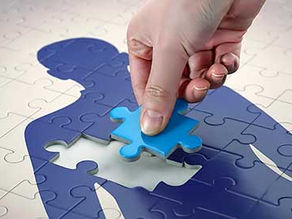 Puzzle pieces put together that show a whole person.