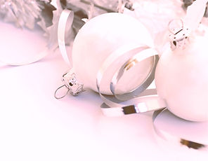 White chistmas bauble decorations with shiny silver curled ribbon on a pastel pink bavkground
