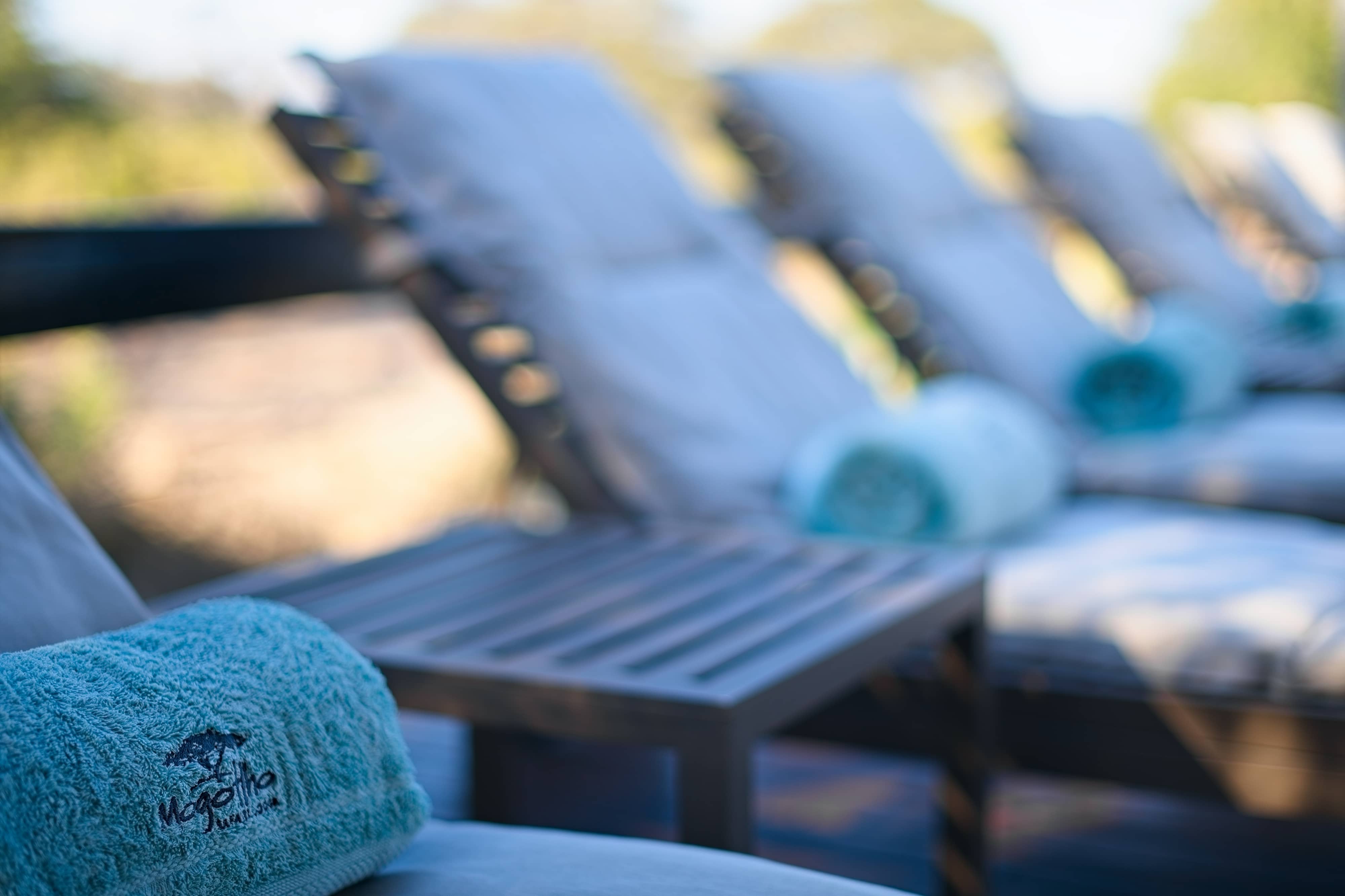 Close up of pool loungers photographed with towels embroidered with the name of the hospitality lodge.
