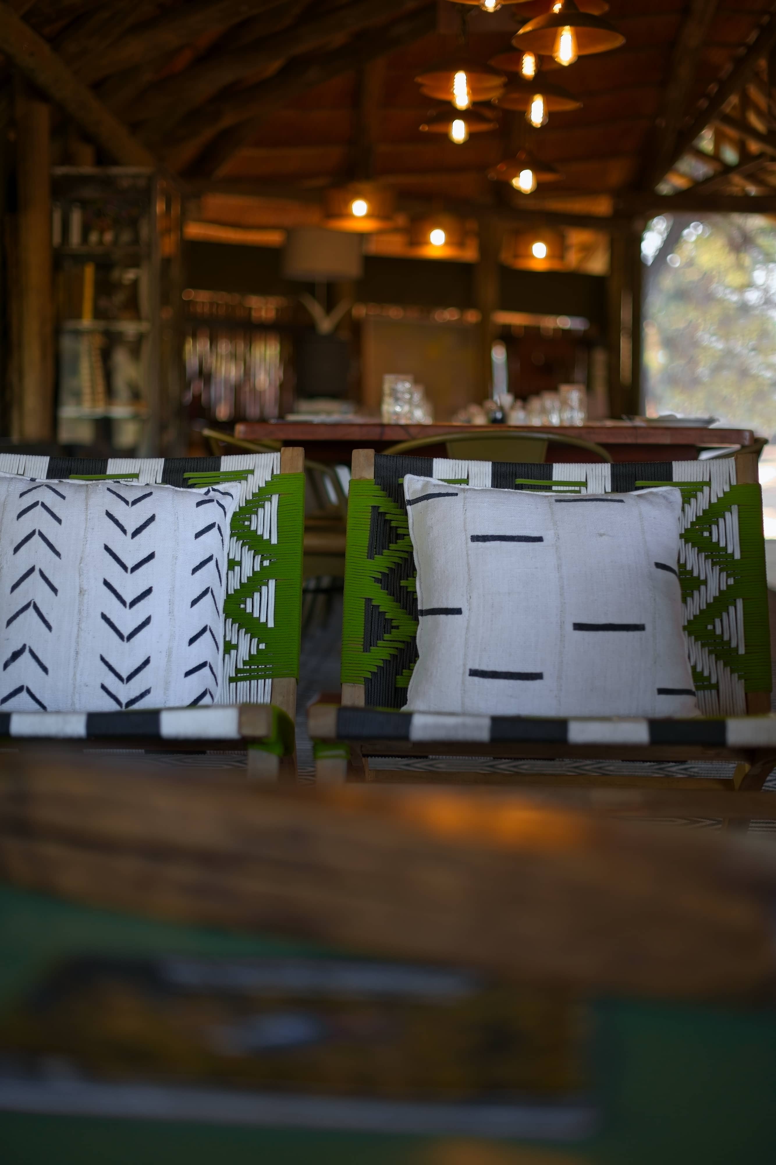 Mogotlho Safari Lodge seating area with modern chairs and african decor cushions photographed with bokeh background