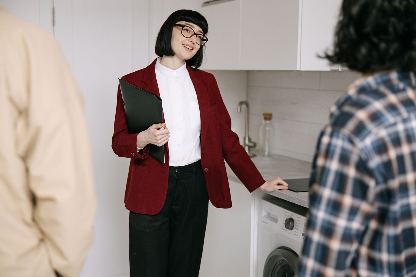 Real estate agent reviewing commission income with clients in a modern kitchen