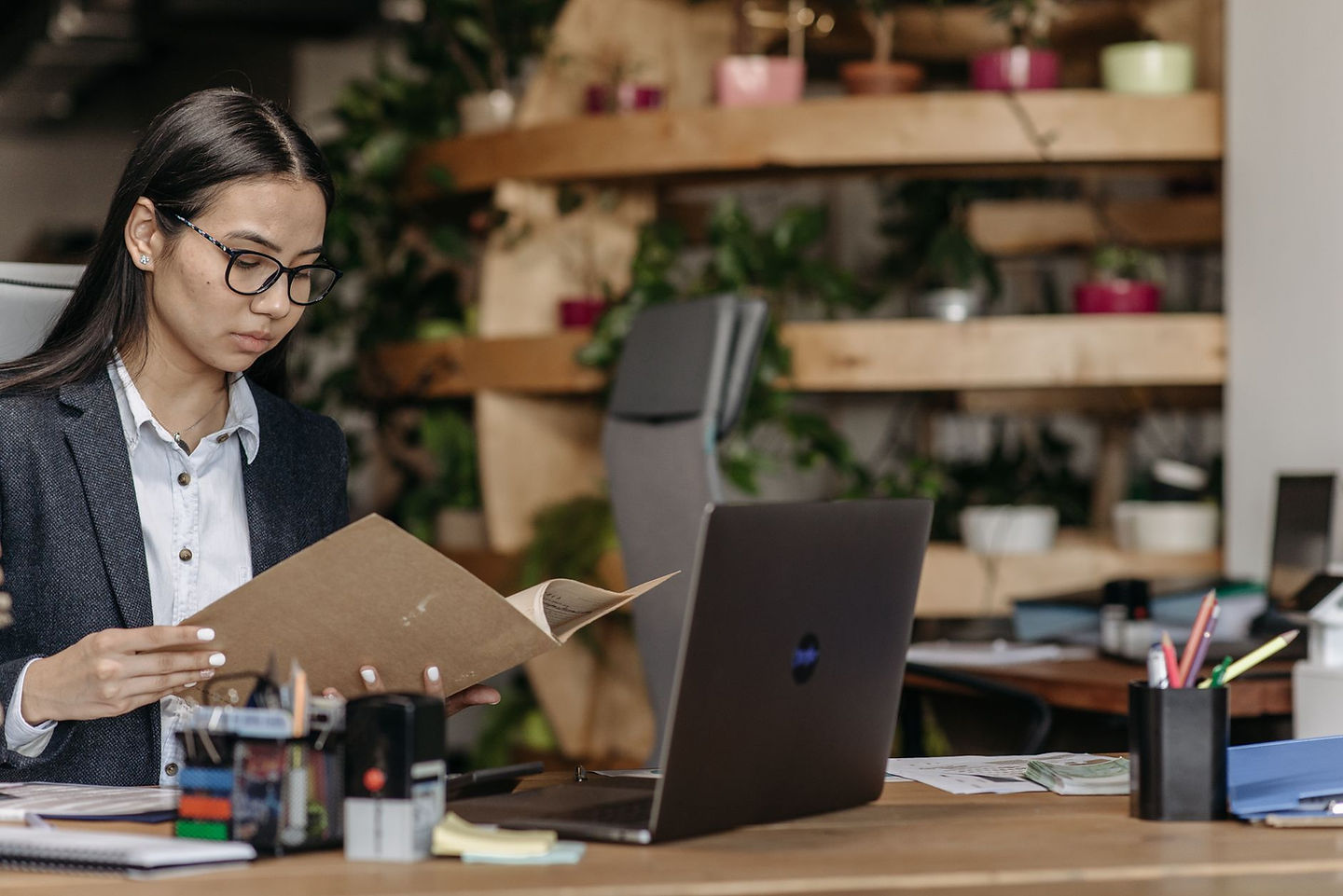 Business owner reviewing grant and tax credit documents on a laptop in a modern office