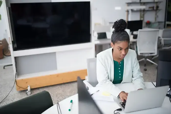 Small business owner reviewing bookkeeping reports on a laptop in a modern office