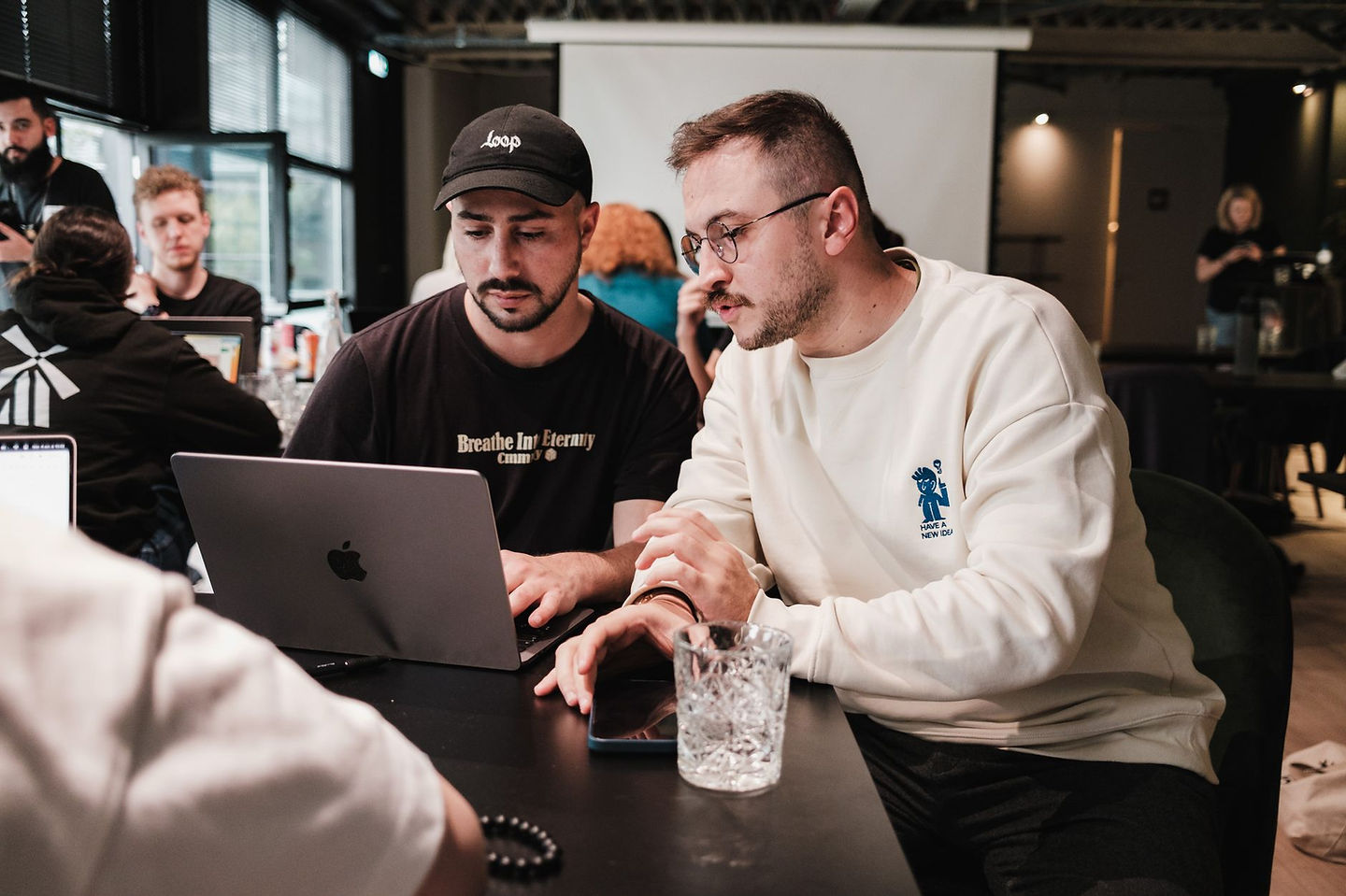 Two Ontario small business owners working through grant paperwork on laptops in a cafe