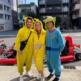 A group dressed up in costume standing in front of Go karts