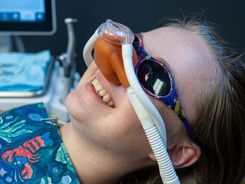 A young girl at the dentist getting treatment using nitrous-oxide
