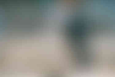 Business traveler walking through a busy airport terminal with a roller suitcase.