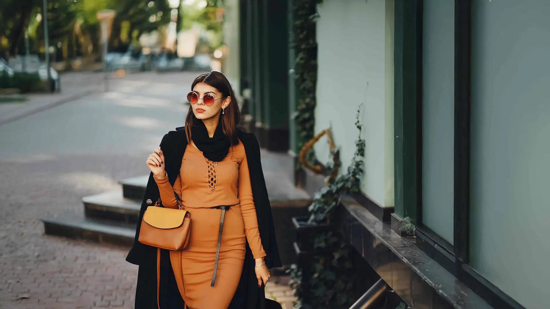 Stylish woman walking outdoors with handbag representing confidence after cosmetic treatments in NYC