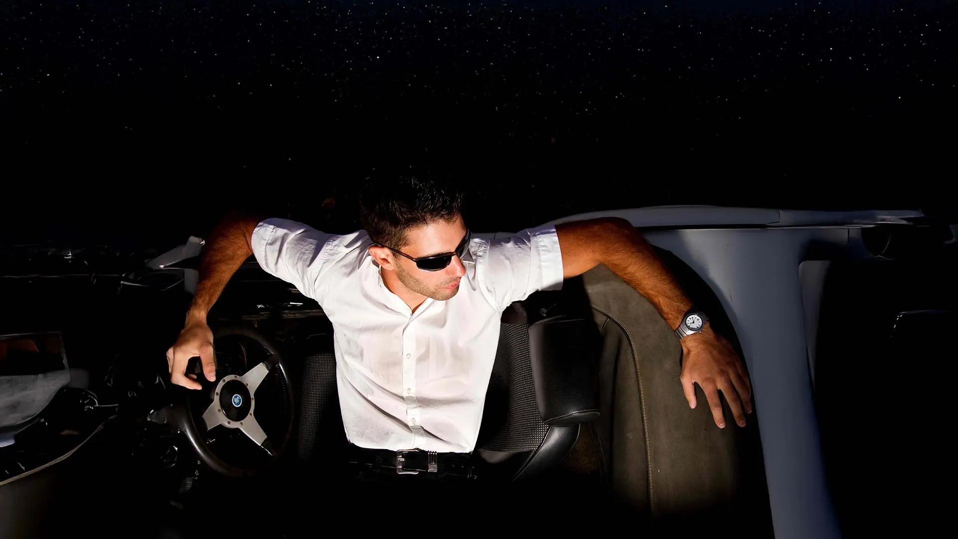 man in sunglasses seated in luxury setting representing men’s aesthetic treatments in NYC