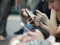 People looking at smartphones, illustrating how social media interactions can lead to assumptions in relationships