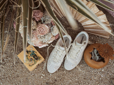 Intimate elopement detail flatlay. Wedding shoes and wooden bouquet, rings on top of a ring box. Joshua tree elopement.