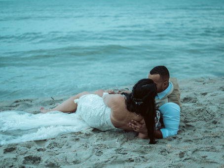 Bride and groom laying in sand on the beach for an intimate adventure elopement. All inclusive beach elopement.