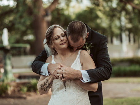 Romantic shot of bride and groom in front of fountain in Savannah, GA